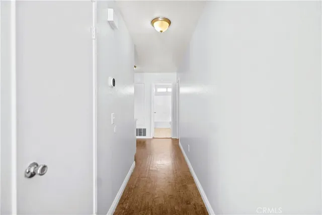 a view of a hallway with wooden floor