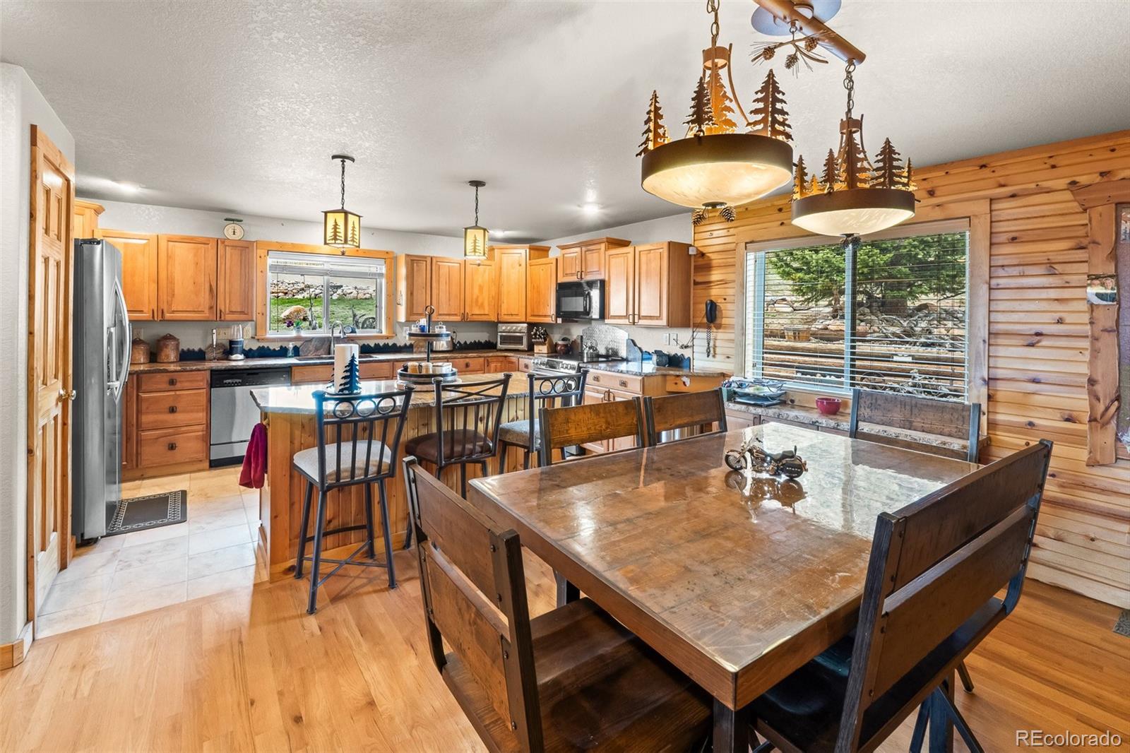 1163 Michigan Hill Road Jefferson, CO 80456 - Photo 5 of 48 an open kitchen with dining table and chairs