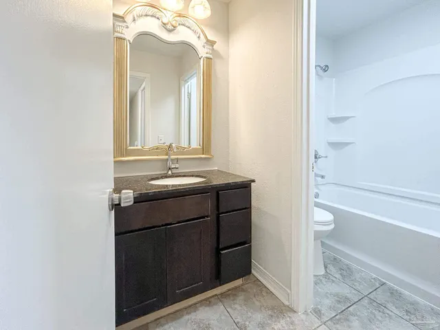 a bathroom with a sink vanity mirror and toilet