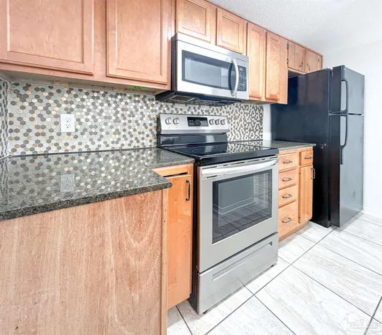 a kitchen with granite countertop cabinets stainless steel appliances and wooden floor
