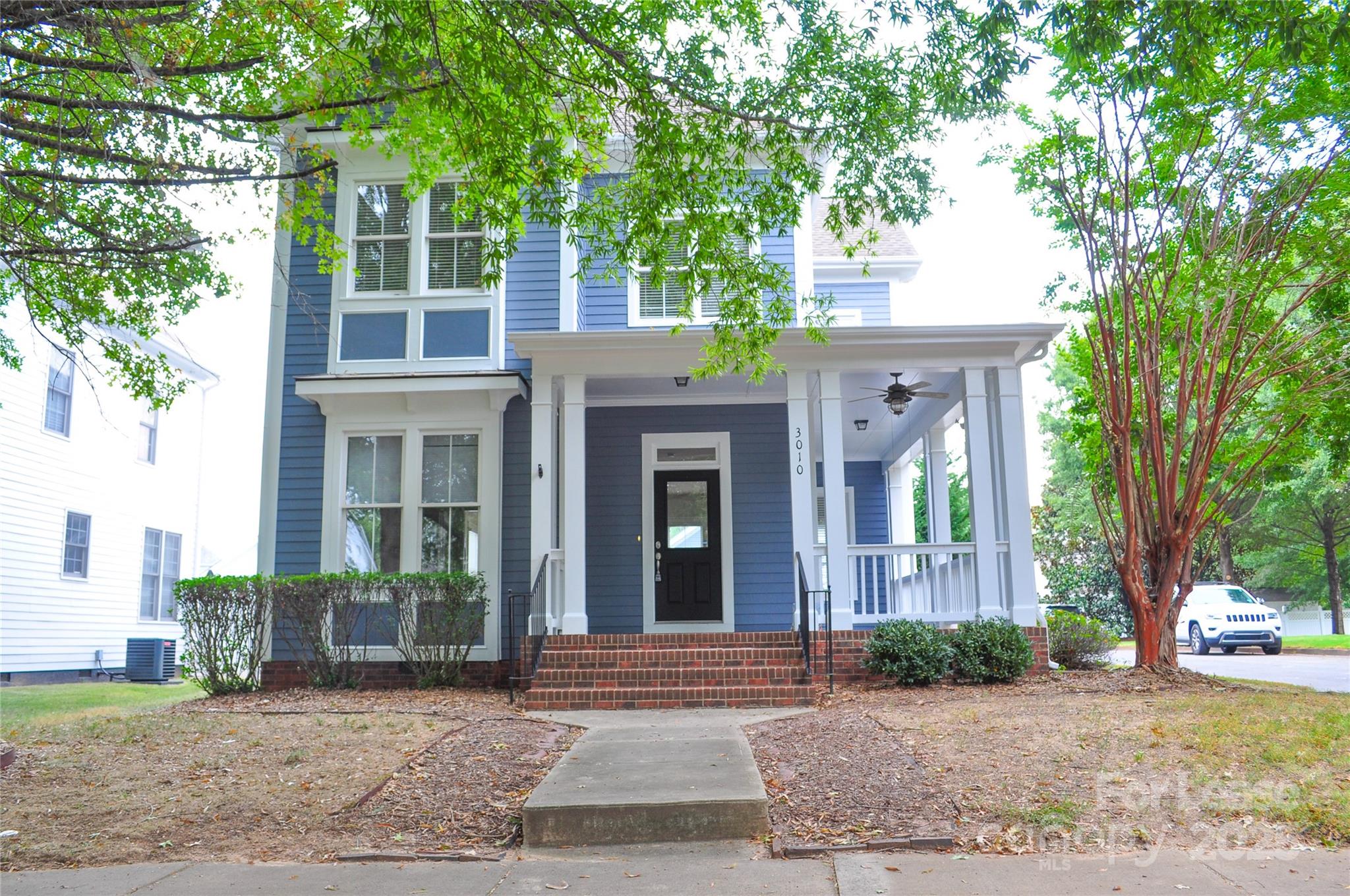 front view of a brick house with a yard