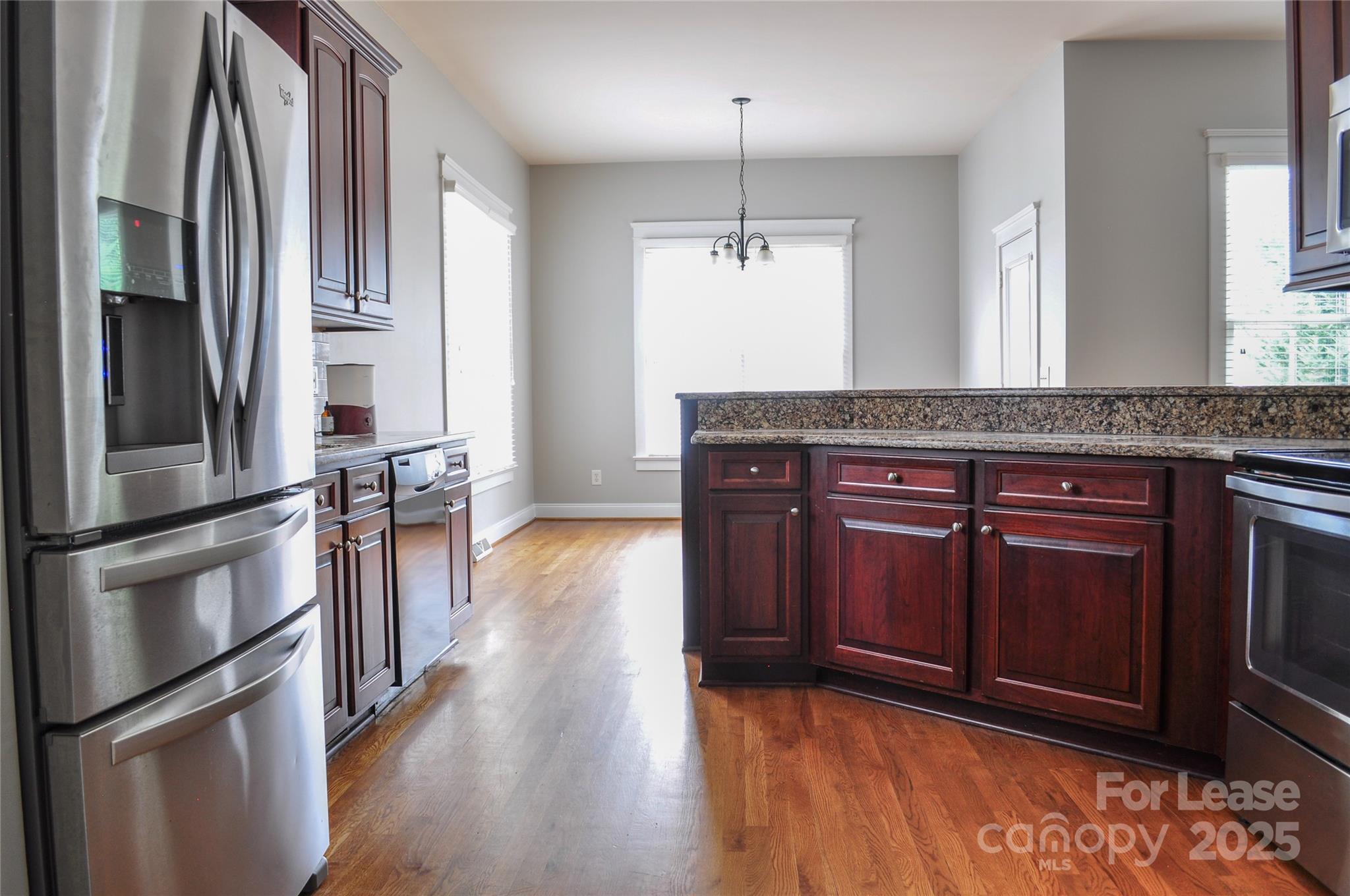 3010 Colonel Springs Way Fort Mill, SC 29708 - Photo 9 of 17 a kitchen with stainless steel appliances granite countertop a refrigerator a stove and a wooden floors