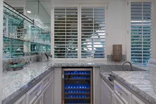 a bathroom with a granite countertop sink a mirror and shower