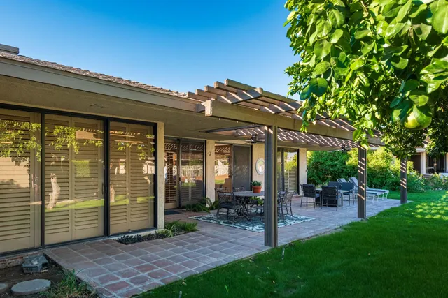 a view of a patio with a table chairs and a backyard