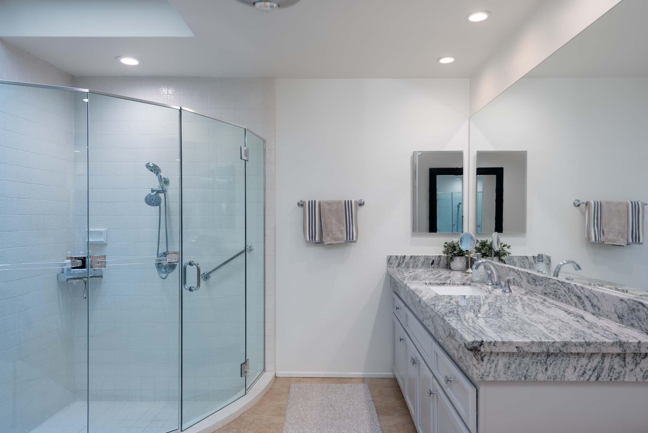 2 Lehigh Court Rancho Mirage, CA 92270 - Photo 32 of 43 a bathroom with a granite countertop sink a mirror and shower