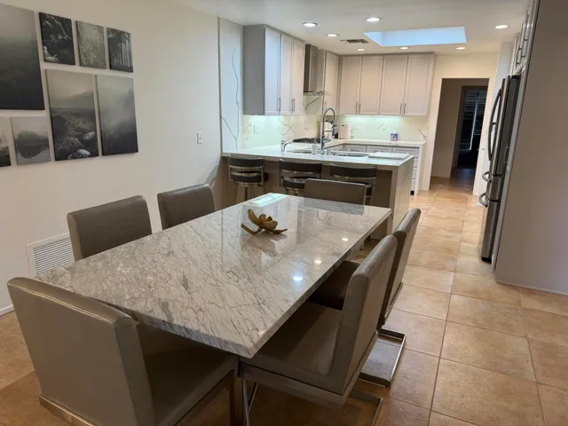 a kitchen with stainless steel appliances granite countertop a sink a refrigerator and a stove