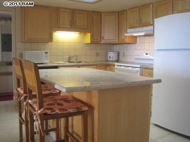 2575 South Kihei Road, Unit G307 Kihei, HI 96753 - Photo 2 of 25 a kitchen with a sink a stove and a refrigerator