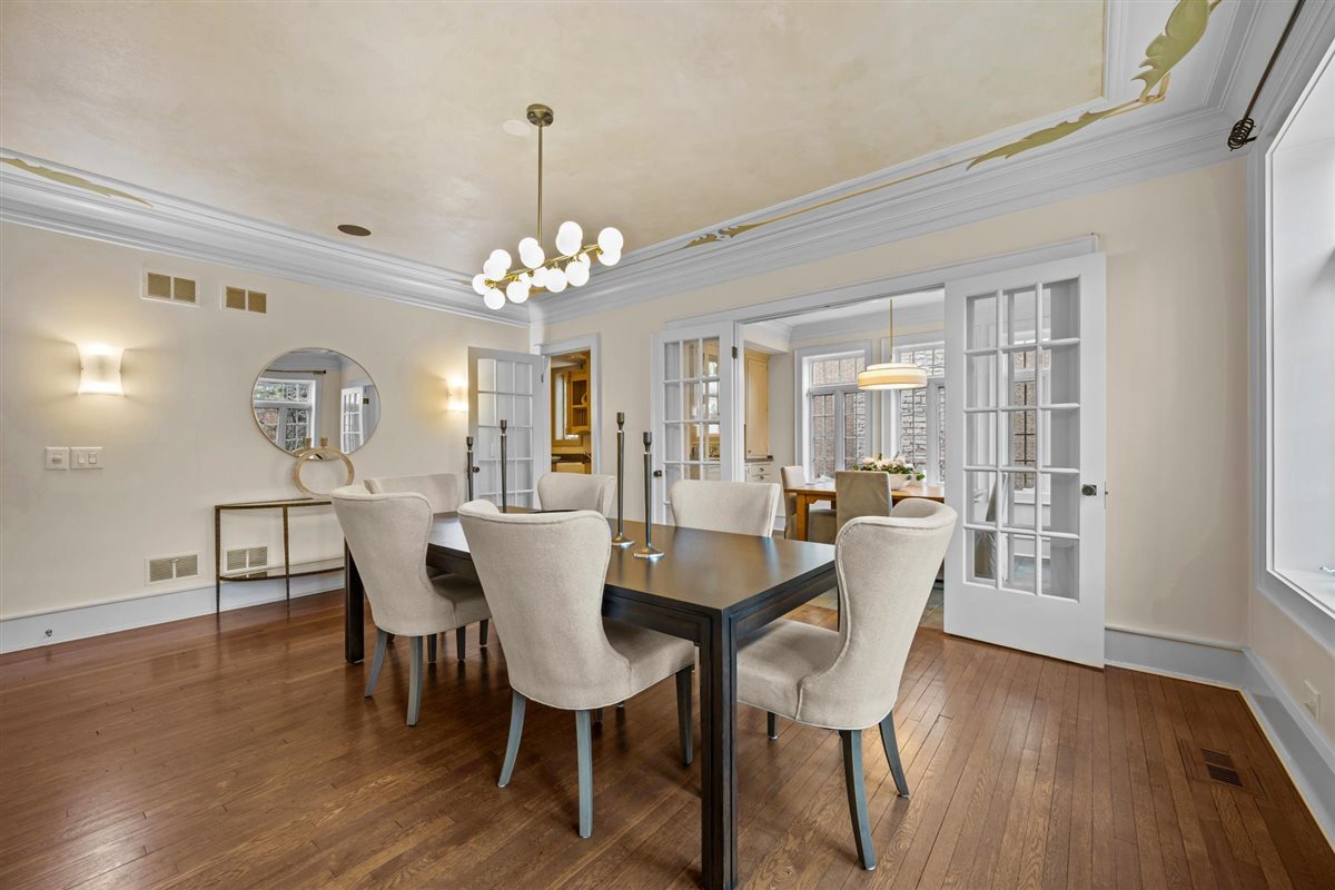 224 Sheridan Road Kenilworth, IL 60043 - Photo 17 of 62 a dining room with wooden floor a chandelier a wooden table and chairs