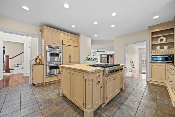 an empty room with wooden floor cabinet and windows