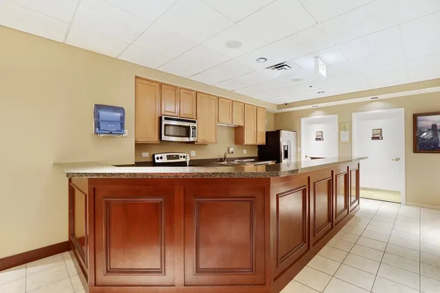 a large kitchen with stainless steel appliances granite countertop a stove and a sink