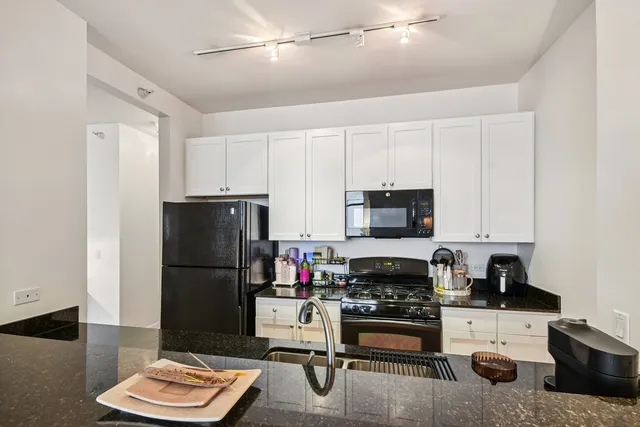 a kitchen with stainless steel appliances granite countertop a refrigerator stove and sink