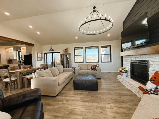 a living room with furniture kitchen view and a large window