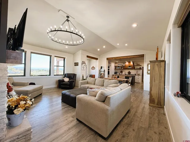 a kitchen with stainless steel appliances kitchen island granite countertop a stove a sink dishwasher and a dining table with wooden floor