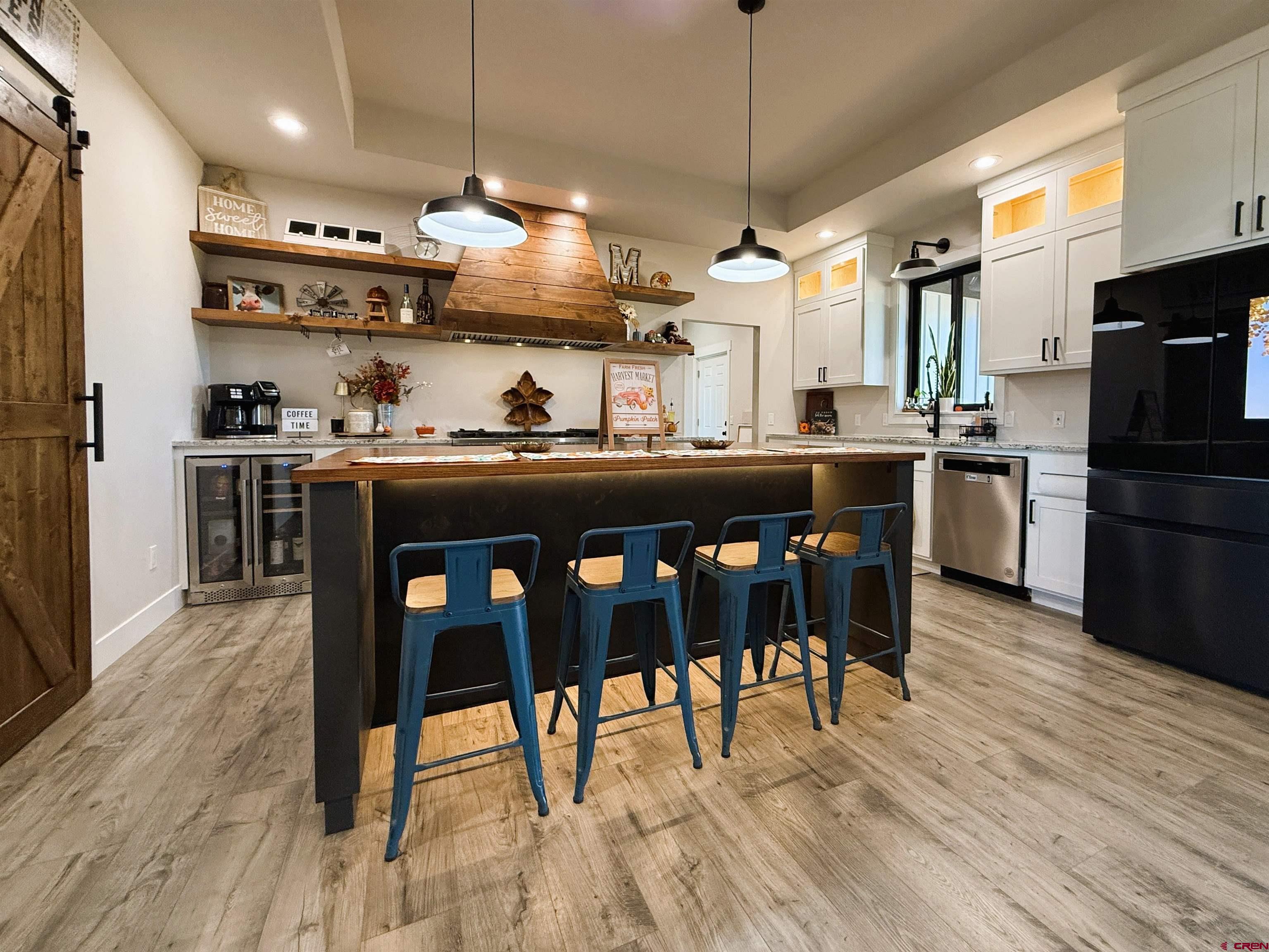 8585 Ellens Way Austin, CO 81410 - Photo 19 of 45 a kitchen with stainless steel appliances granite countertop wooden floors and wooden cabinets