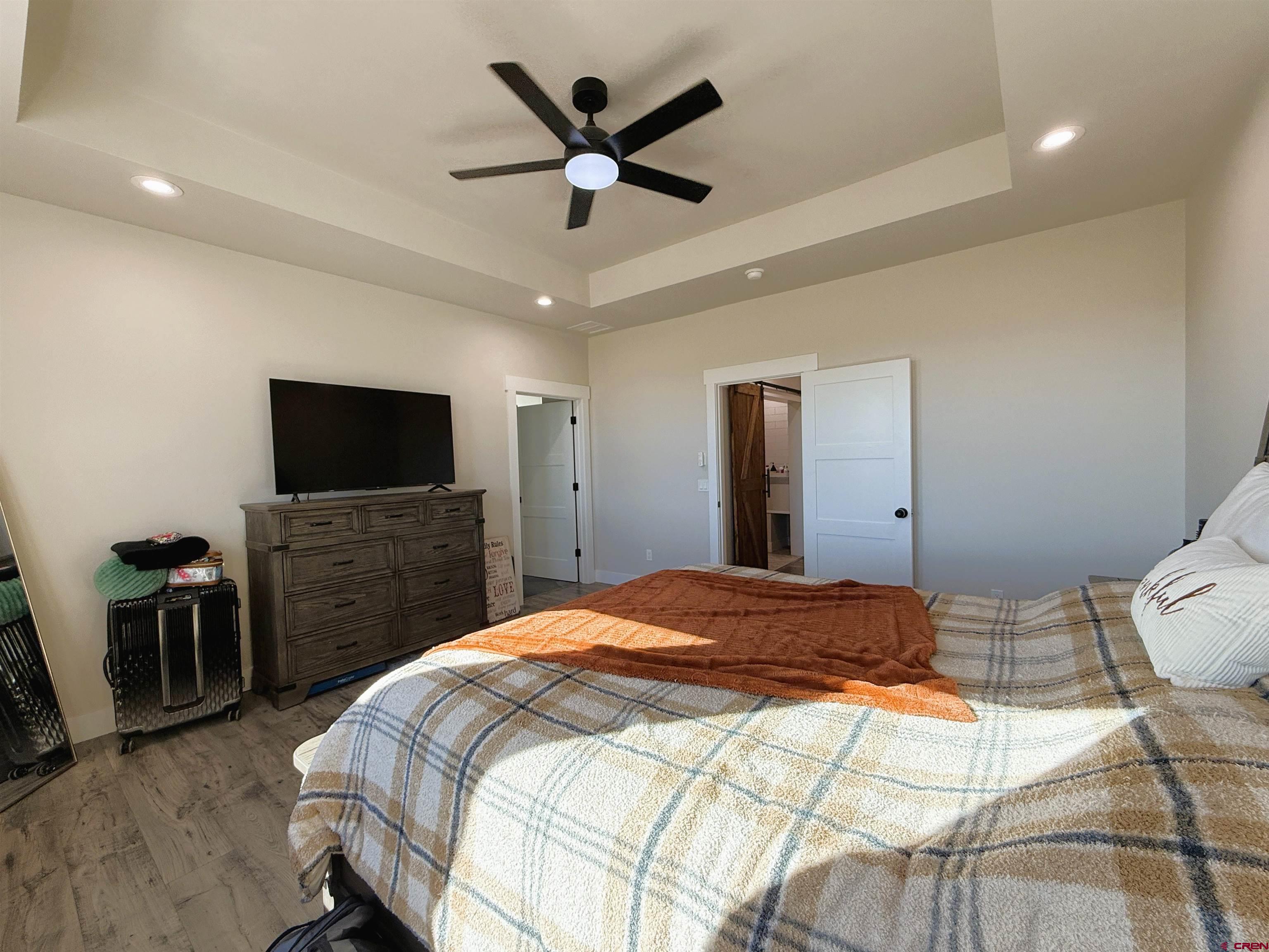 8585 Ellens Way Austin, CO 81410 - Photo 32 of 45 a bedroom with a bed and a flat screen tv