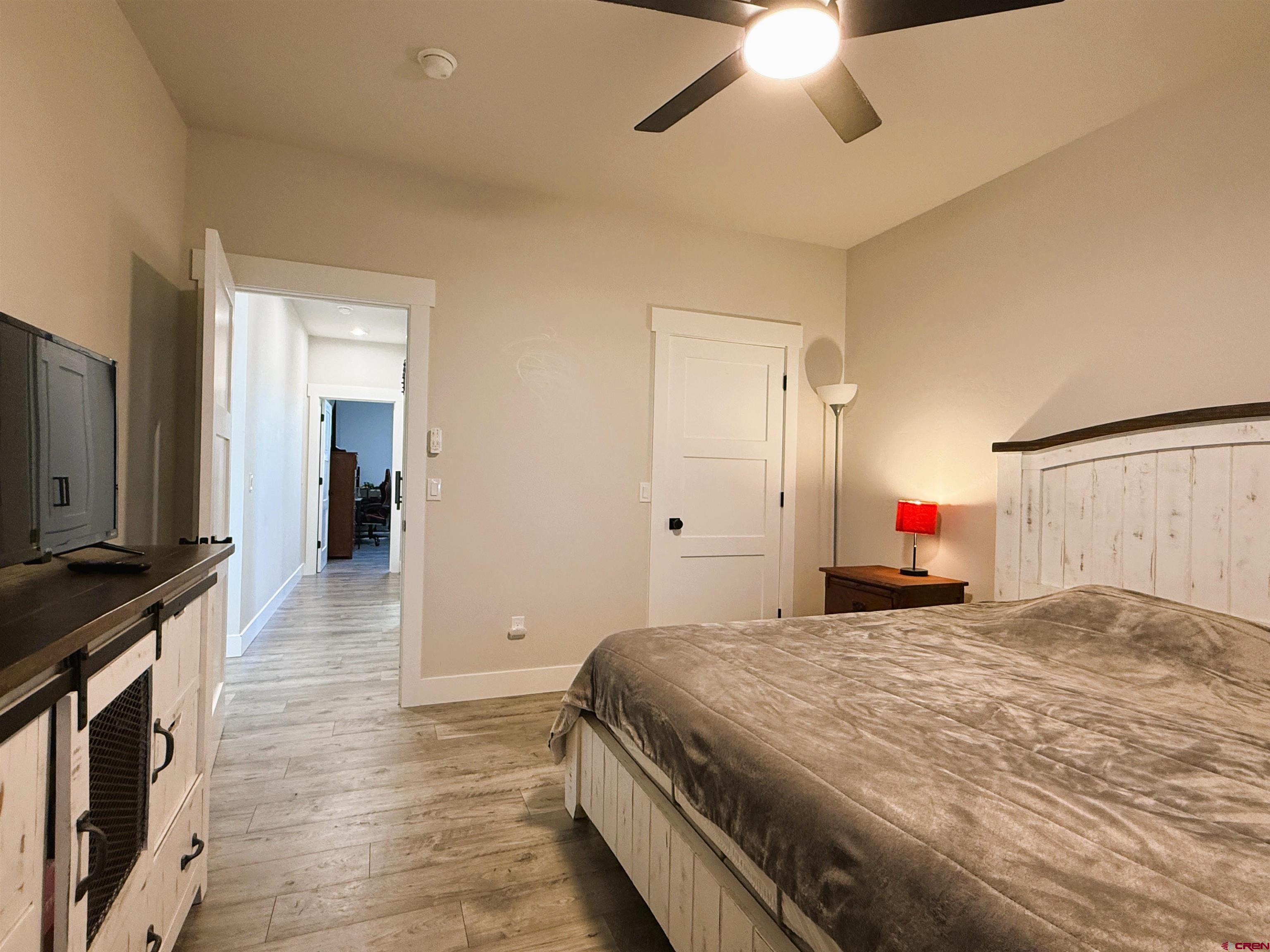 8585 Ellens Way Austin, CO 81410 - Photo 45 of 45 a spacious bedroom with a bed and a chandelier