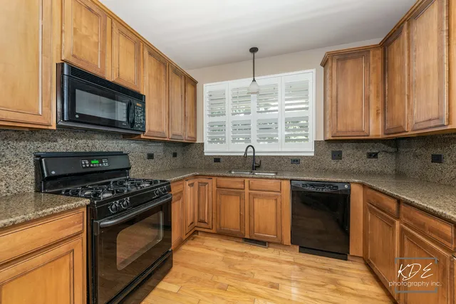 a kitchen with stainless steel appliances granite countertop a stove a refrigerator and a microwave