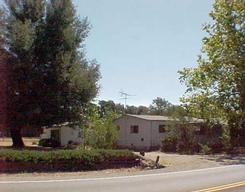 6759 Airport Road Redding, CA 96002 - Photo 1 of 1 a front view of a house with a yard and garage