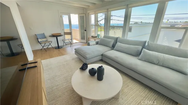 a living room with furniture and a floor to ceiling window