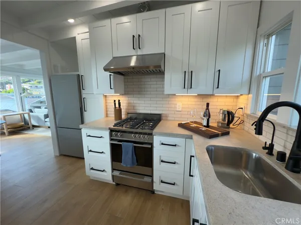a kitchen with granite countertop a sink and a stove top oven