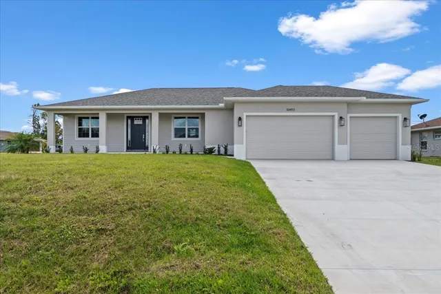 a view of a house with a yard and potted plants
