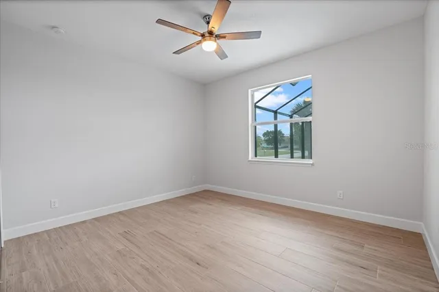 an empty room with a window and a fan