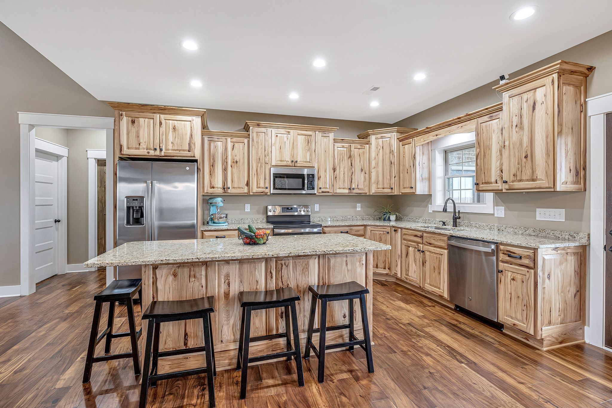 164 Haley Road Wartrace, TN 37183 - Photo 7 of 45 a kitchen with kitchen island granite countertop wooden floors and white cabinets