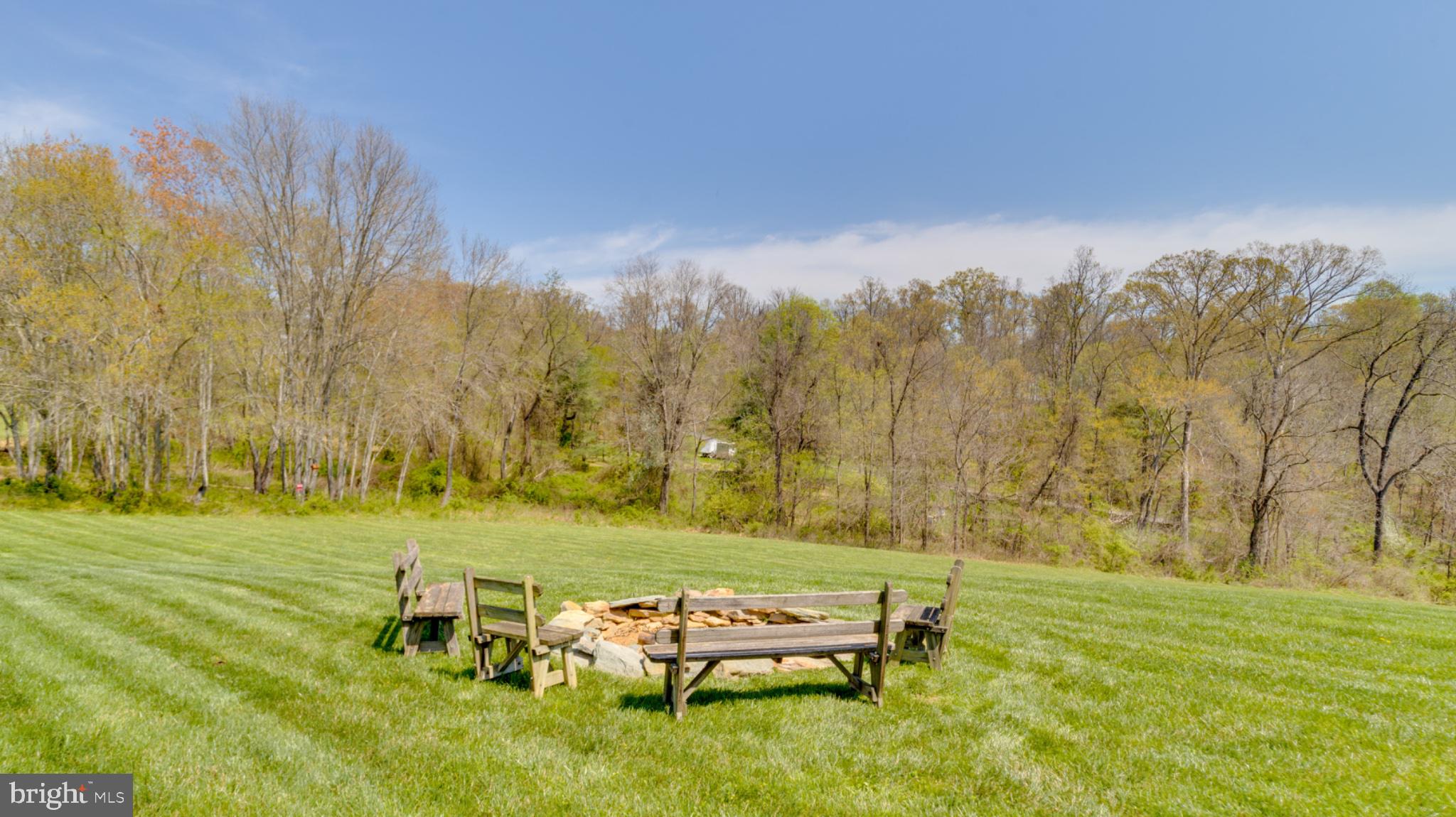 1296 Macton Road Street, MD 21154 - Photo 11 of 34 Serene fire pit in lush greenery.