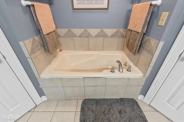 a bedroom with a bed and a flat screen tv in white dresser