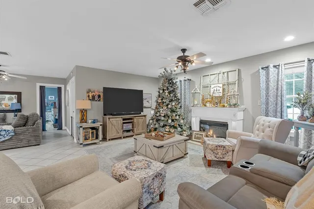 a living room with furniture a flat screen tv and a chandelier