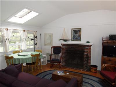 15 Massasoit Road, Unit 2 Wellfleet, MA 02667 - Photo 4 of 11 a dining room with furniture a window and a fireplace