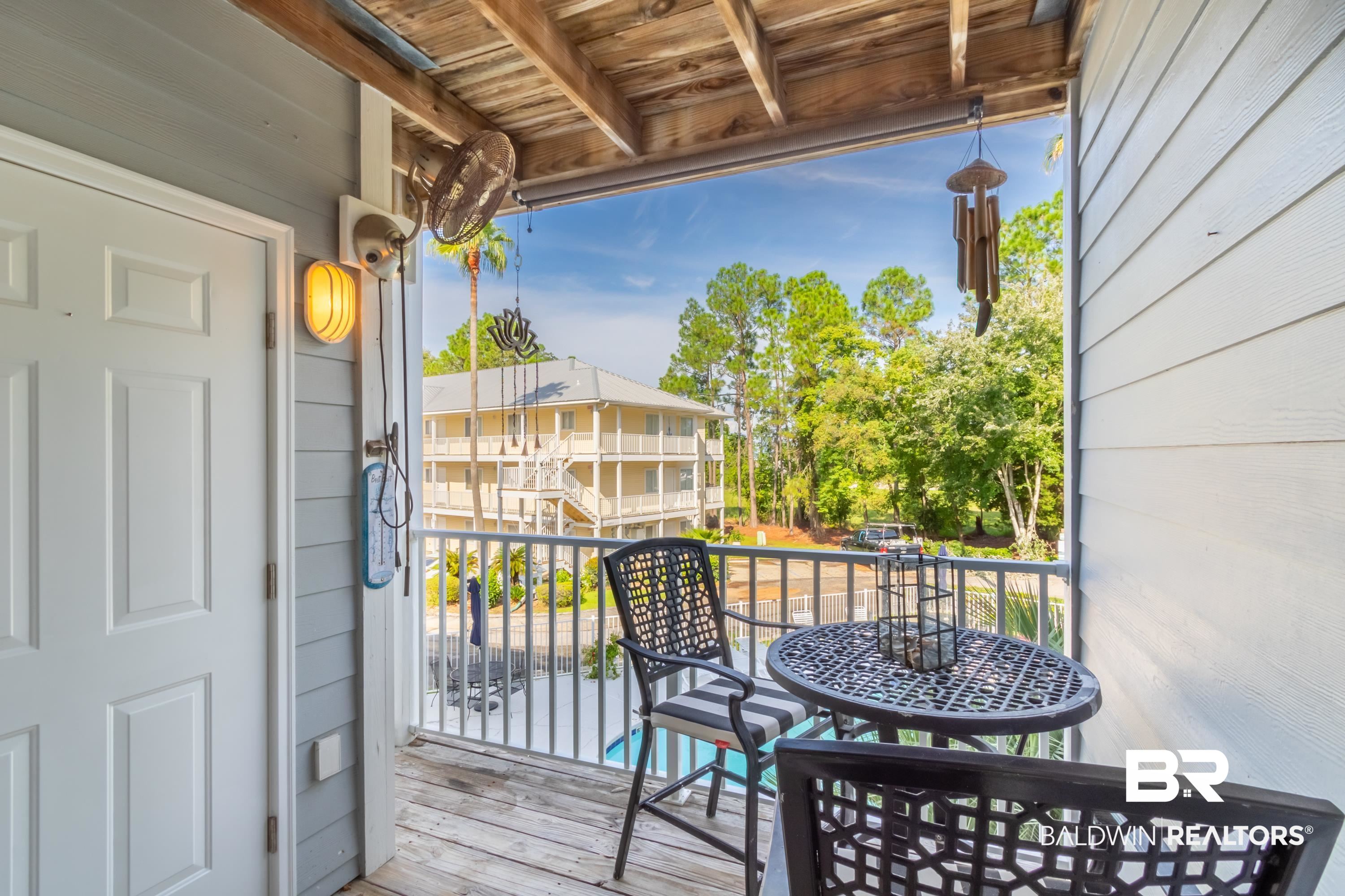 25957 Canal Road, Unit 208 Orange Beach, AL 36561 - Photo 10 of 28 Outdoor balcony with wood-finish flooring, light blue siding, and a white paneled door