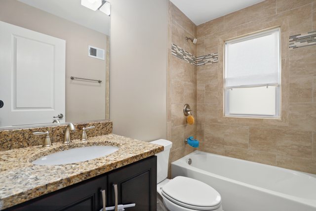 934 Spring Road Elmhurst, IL 60126 - Photo 14 of 27 a bathroom with a granite countertop sink toilet and shower