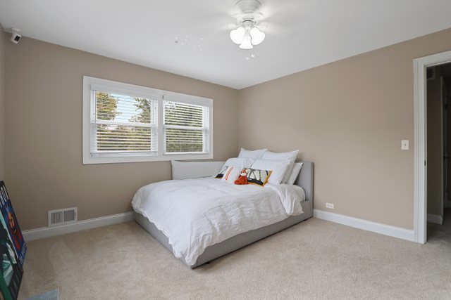 934 Spring Road Elmhurst, IL 60126 - Photo 22 of 27 a bedroom with a bed next to a window and a chandelier