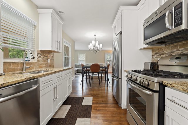 934 Spring Road Elmhurst, IL 60126 - Photo 8 of 27 a kitchen with stainless steel appliances granite countertop a stove top oven a sink dishwasher a dining table and chairs with wooden floor