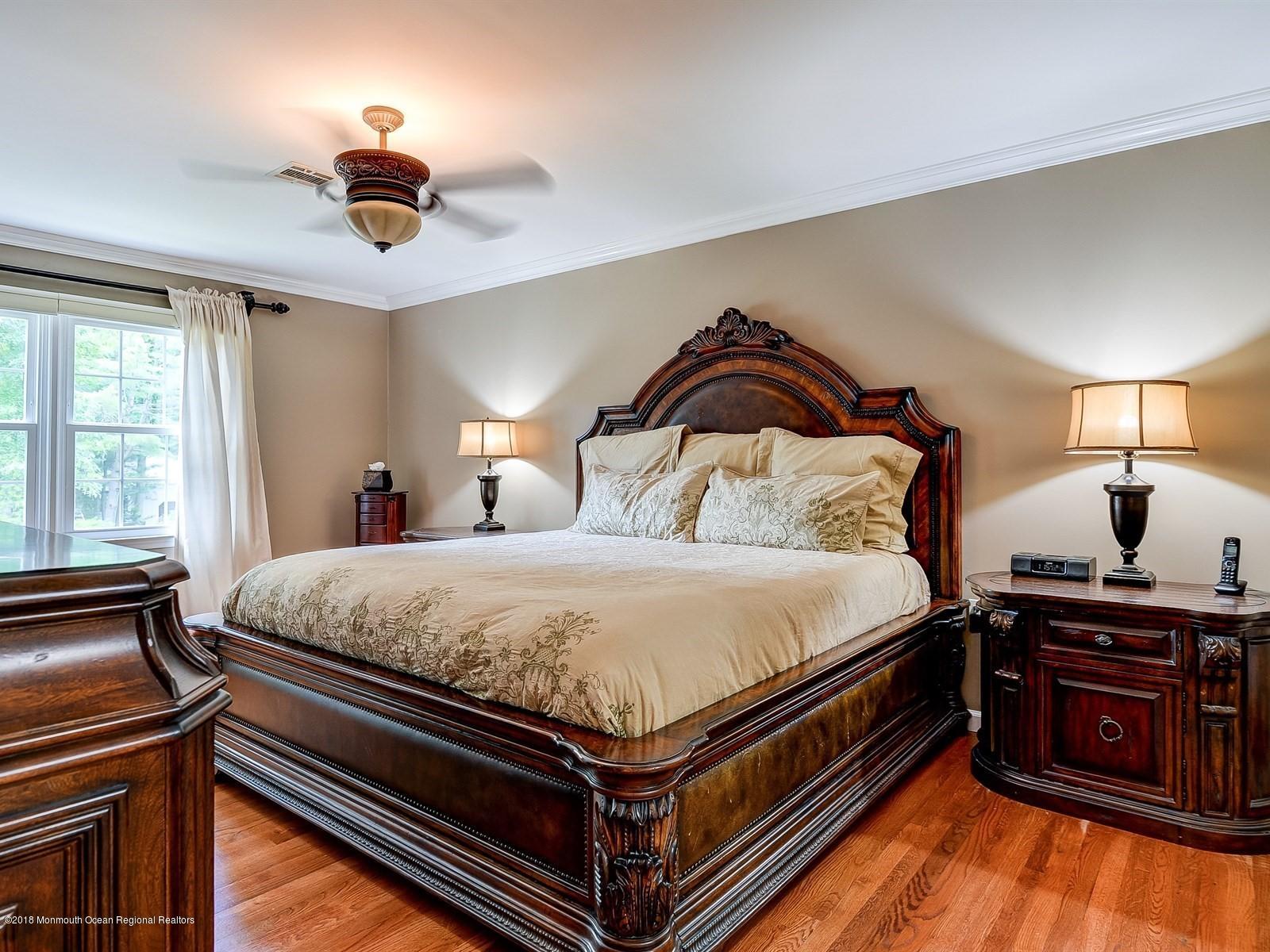 16 Canvasback Road Manalapan, NJ 07726 - Photo 14 of 26 a bedroom with a bed and a chandelier