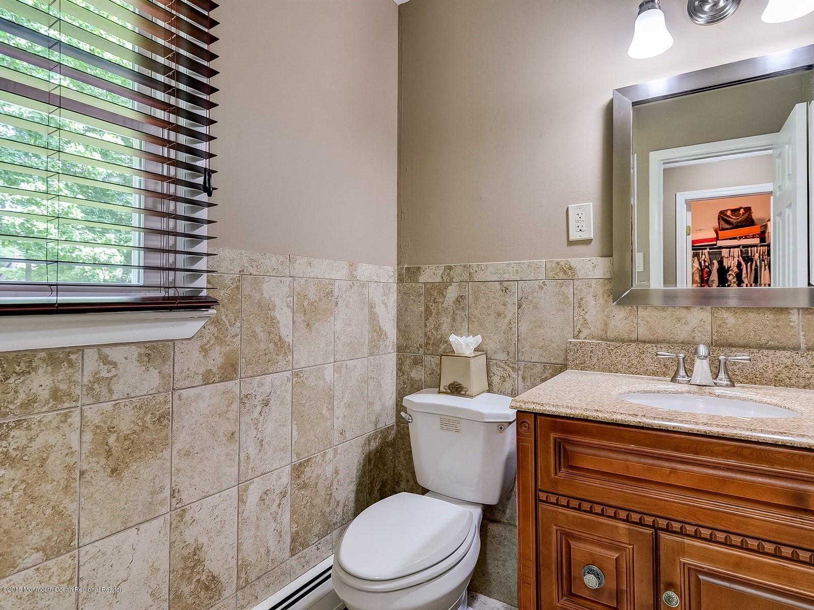 16 Canvasback Road Manalapan, NJ 07726 - Photo 16 of 26 a bathroom with a sink a toilet and mirror