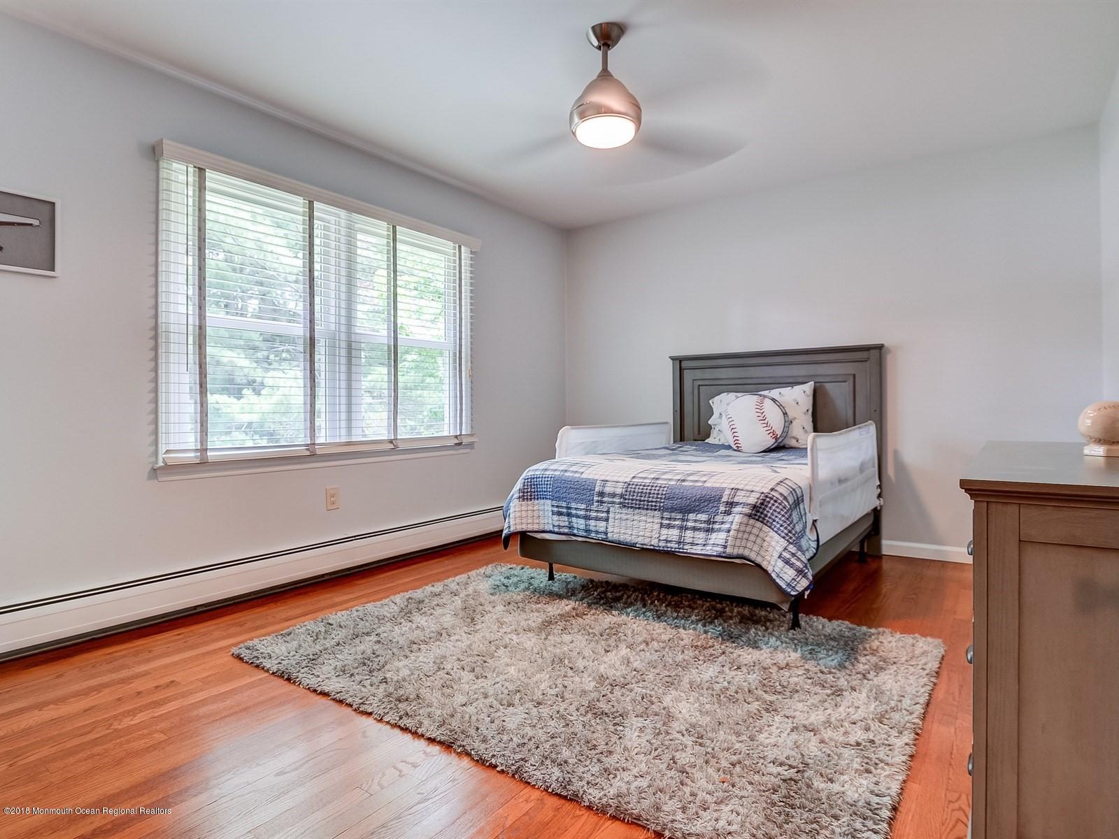 16 Canvasback Road Manalapan, NJ 07726 - Photo 18 of 26 a bedroom with a bed and wooden floor