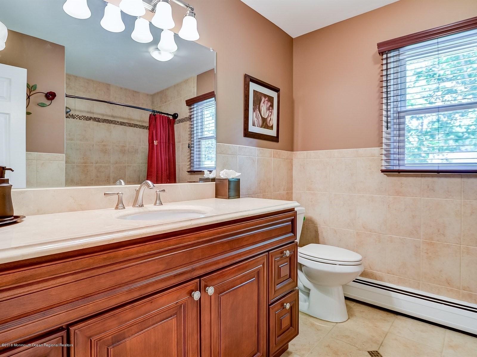 16 Canvasback Road Manalapan, NJ 07726 - Photo 21 of 26 a bathroom with a sink a toilet and a mirror