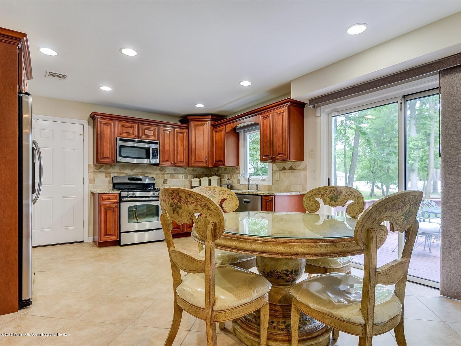 16 Canvasback Road Manalapan, NJ 07726 - Photo 10 of 26 a view of a dining room with furniture a kitchen and chandelier