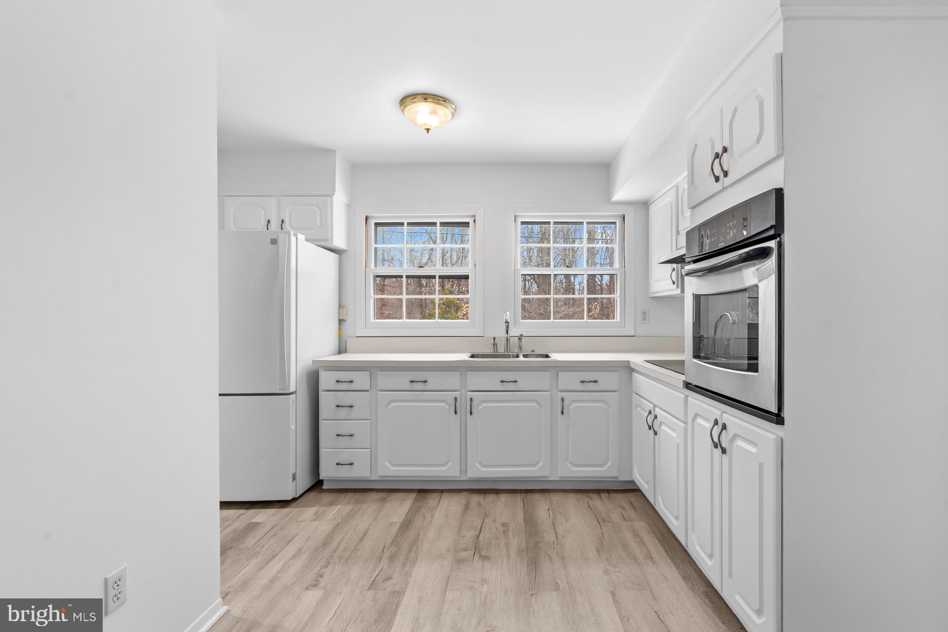 12202 Rustic Hill Drive Bowie, MD 20715 - Photo 11 of 34 a kitchen with granite countertop a sink stove and refrigerator