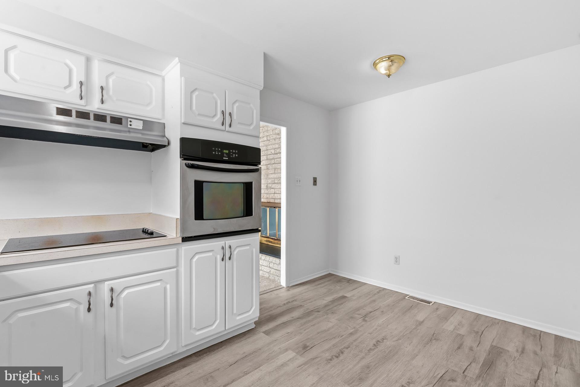 12202 Rustic Hill Drive Bowie, MD 20715 - Photo 12 of 34 a kitchen with granite countertop white cabinets and stainless steel appliances