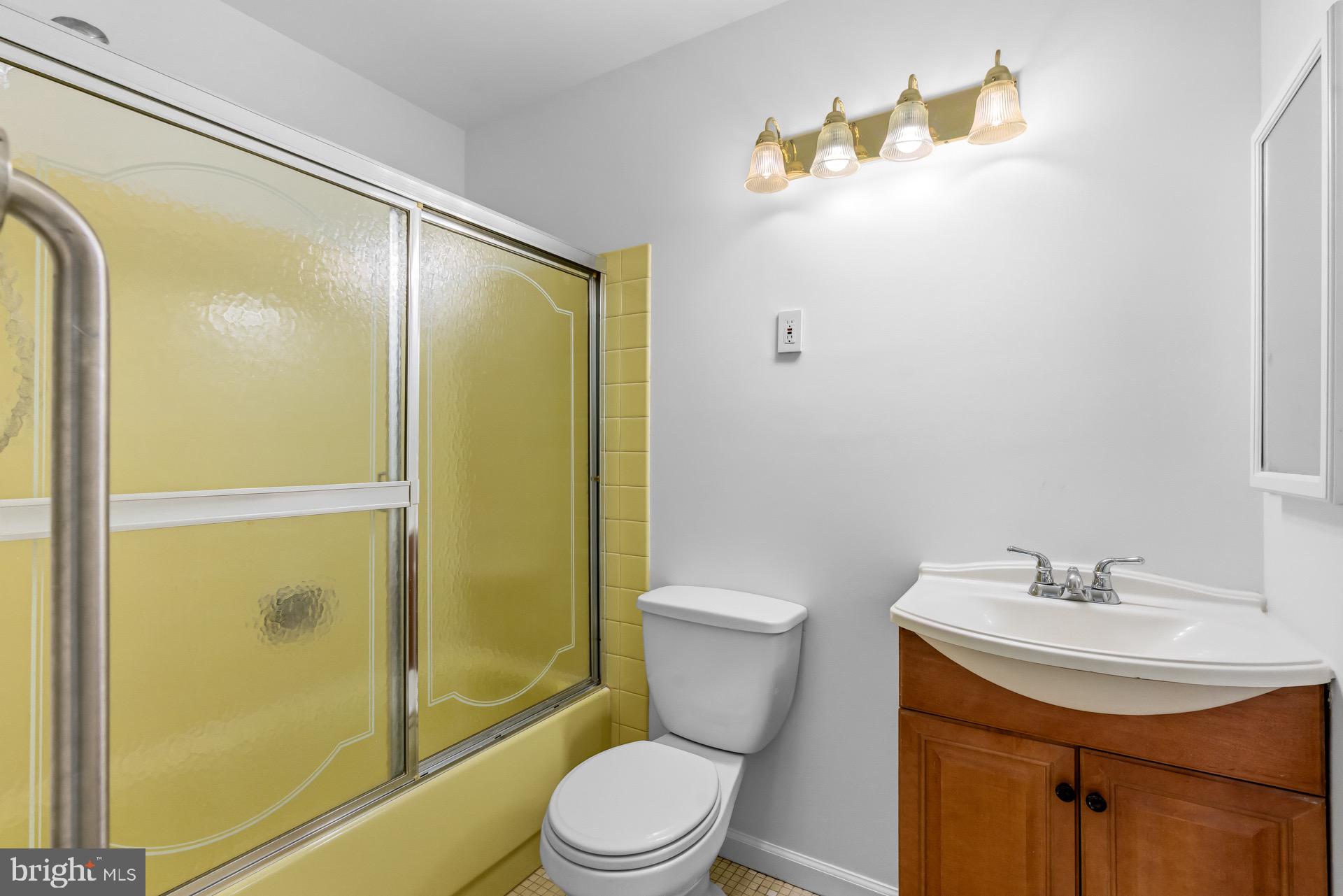12202 Rustic Hill Drive Bowie, MD 20715 - Photo 22 of 34 a bathroom with a sink mirror toilet and shower