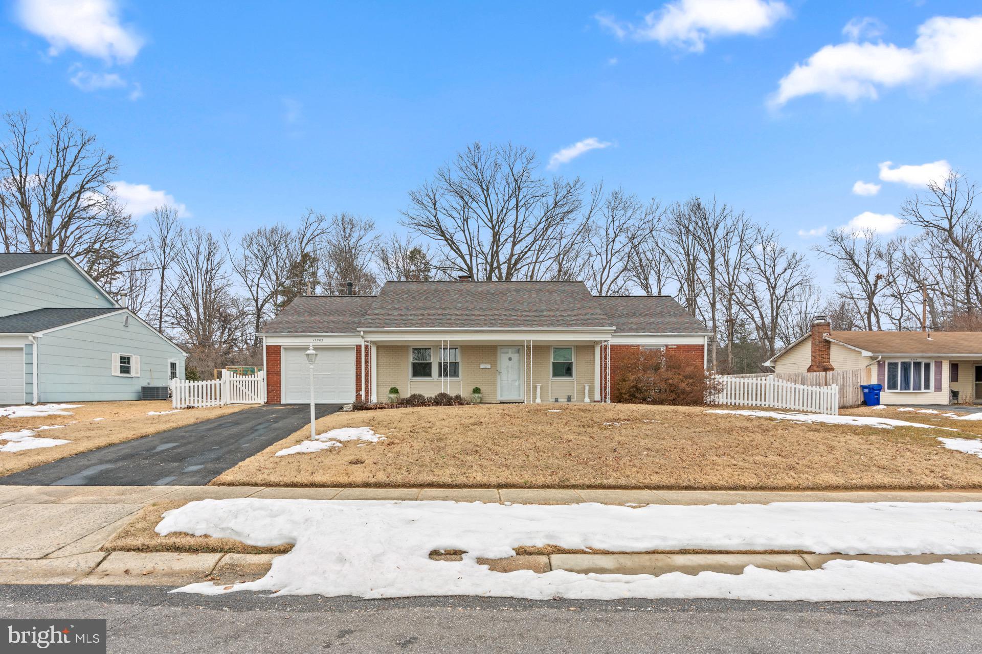12202 Rustic Hill Drive Bowie, MD 20715 - Photo 3 of 34 a front view of a house with a yard and trees