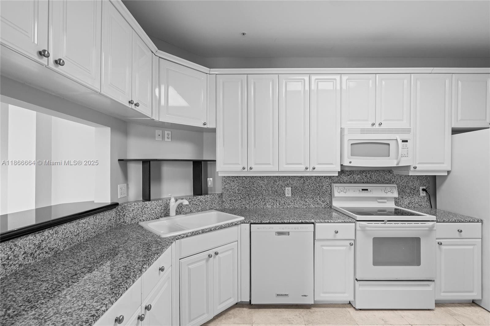 888 Brickell Key Drive, Unit 408 Miami, FL 33131 - Photo 17 of 54 a kitchen with granite countertop a sink stainless steel appliances and white cabinets