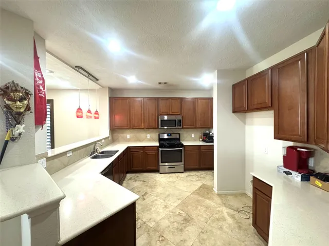 a kitchen with stainless steel appliances granite countertop a sink refrigerator and cabinets