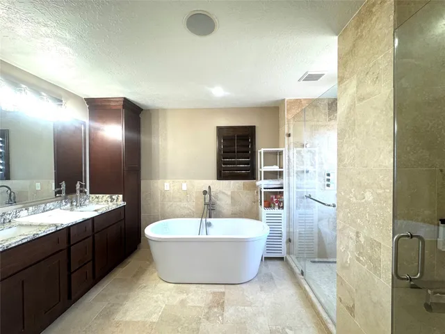 a spacious bathroom with a double vanity sink a mirror and a bathtub