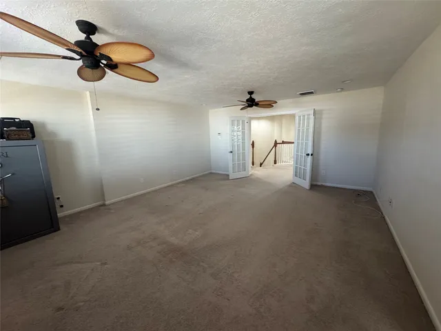 a view of empty room with ceiling fan