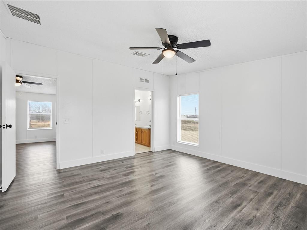 229 Morgan Road Italy, TX 76651 - Photo 13 of 40 a view of an empty room with wooden floor and a ceiling fan