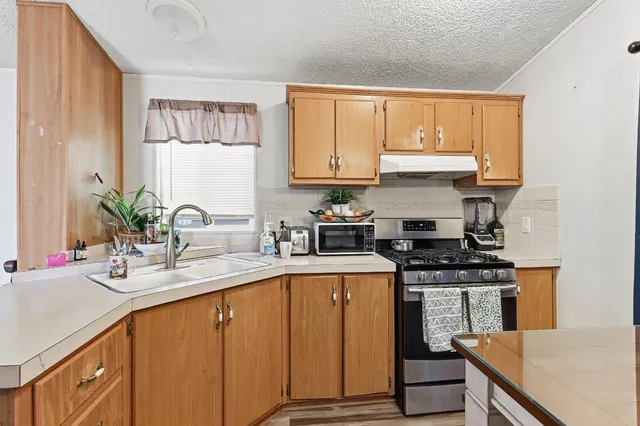 a kitchen with stainless steel appliances granite countertop a sink stove and cabinets